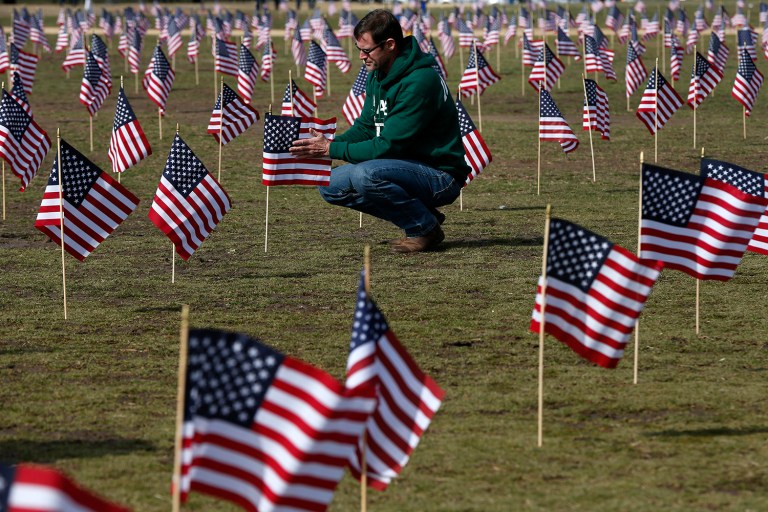A Navy veteran places 1,892 flags representing veteran and service members who have died by suicide to date in 2014. Overall in 2014, at least 7,403 U.S. veterans killed themselves. (AP Photo/Charles Dharapak)