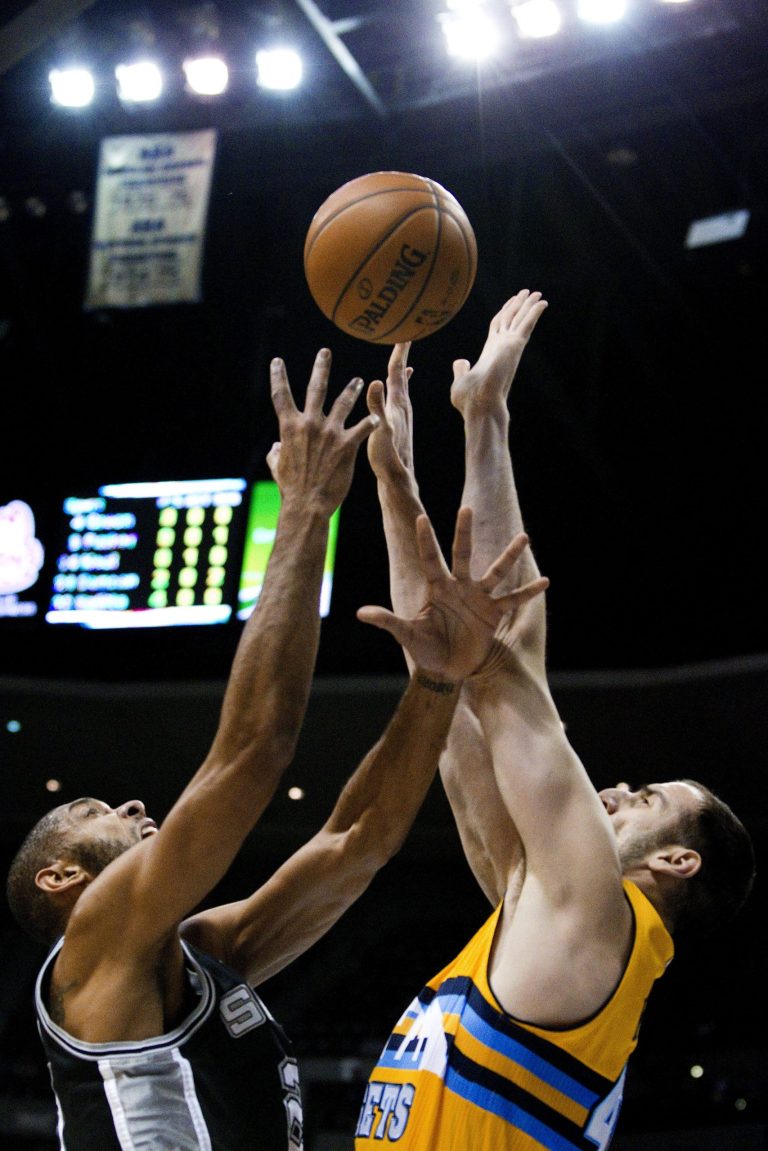  San Antonio Spurs' Tim Duncan, left, and Denver Nuggets' Kosta Koufos, right, compete for a rebound during the first quarter of an NBA basketball game Tuesday, Dec. 18, 2012, in Denver. (AP Photo/Barry Gutierrez)  