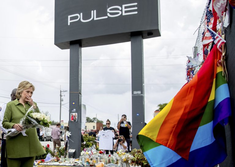 Democratic presidential candidate Hillary Clinton carries a bouquet of flowers as she visits a memorial outside of the Pulse nightclub in Orlando, Friday, July 22, 2016, which was the site of the June 12 massacre. (AP Photo/Andrew Harnik)
