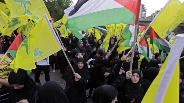 Hezbollah supporters wave Hezbollah and Palestinian flags during a demonstration against the Israeli offensive in Gaza near UN headquarters in Beirut, Lebanon, on Saturday, November 17, 2012. (photo credit: AP Photo/Bilal Hussein)