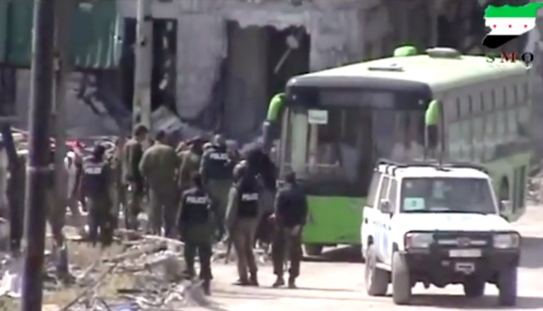 In this image made from amateur video released by Ugarit News, which has been authenticated based on its contents and other AP reporting, Syrian rebels board a bus to leave Homs, Syria, Wednesday, May 7, 2014. Exhausted and worn out from a year-long siege, hundreds of Syrian rebels on Wednesday left their last remaining bastions in the heart of the central city of Homs under a cease-fire deal with government forces. The exit of some 1,200 fighters and civilians will mark a de facto end of the rebellion in the battered city, which was one of the first places to rise up against President Bashar Assad's rule, earning it the nickname of 