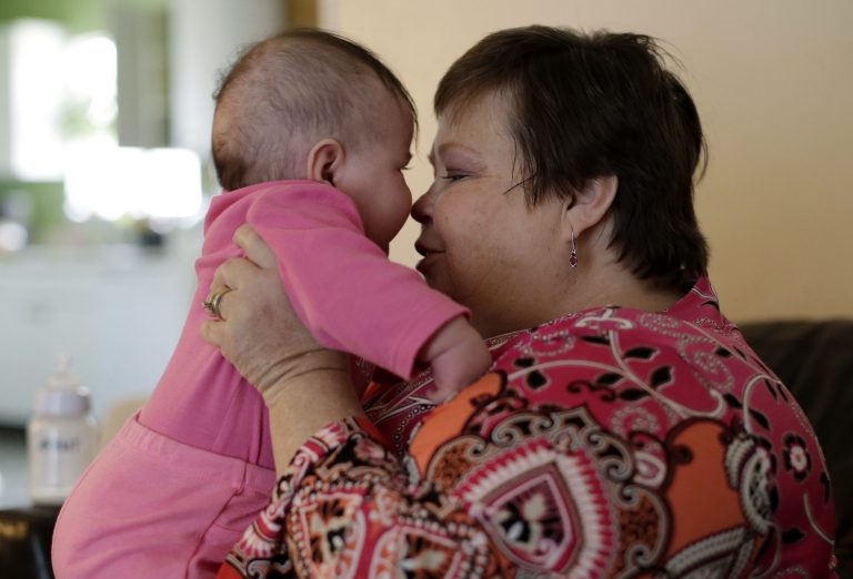 In this Monday, Feb. 3, 2014, photo, Mary-Jane Harrison spends time with her granddaughter, Robyn, in San Antonio. Like nearly 78 million American adults, Harrison is obese, and because of stress fractures in her legs she is unable to able to walk up or down the stairs of her two-story home. (AP Photo/Eric Gay)