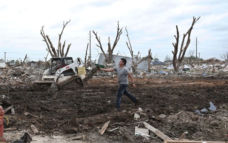 David Cabral, of Demolition and Debris Removal, helps to clear a lot in Moore, Okla., on June 19 after a tornado ripped through the area. (AP Photo/Sue Ogrocki)