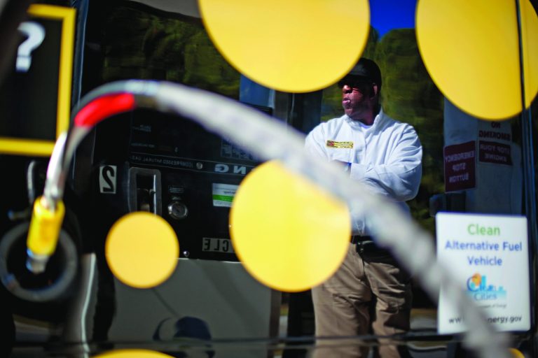 FILE - In this Thursday, Oct. 27, 2011 file photo, motorist Bob Davis is reflected in his airport shuttle van as he fills up at a natural gas pumping station in College Park, Ga. Years from now, motorists needing a fill-up might see natural gas pumps sharing space at the neighborhood filling station with ones dispensing gasoline and diesel. (AP Photo/David Goldman, File)