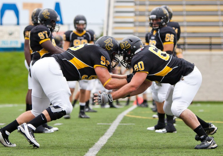   In this 2012 photo provided by Adrian College, members of the school's Bulldog football team warm up before homecoming in Adrian, Mich. Adrian's president, Jeffrey Docking, has added seven sports and two pre-professional degree programs to the liberal arts college since arriving in 2005 _ and nearly doubled enrollment to about 1,750. (AP Photo/Adrian College, Matt Gaidica Photography)  