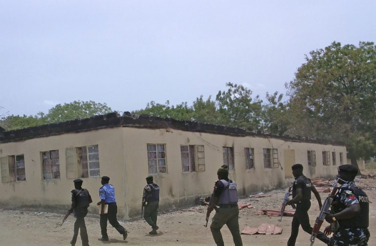 Security guards walk past a burnt out government secondary school in Chibok, Nigeria, where gunmen abducted more than 200 students, in this file photo taken on Monday, April, 21, 2014. (AP Photo/ Haruna Umar,File)