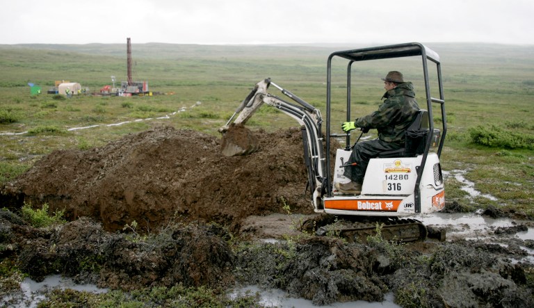 FILE - In this July 13, 2007 file photo, a worker with the Pebble Mine project digs in the Bristol Bay region of Alaska near the village of Iliamma, Alaska. The Trump administration settled a lawsuit Friday, May 12, 2017, over the proposed development of a massive copper and gold deposit near the headwaters of a world-premier salmon fishery in southwest Alaska.