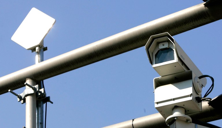 A surveillance camera, right, and a transmitter, left, are seen near the top of a traffic light pole in Newark, N.J.