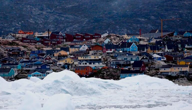 Floating ice, left over from broken-up icebergs shed from the Greenland ice sheet, nearly cover the seafront in Ilulissat, Greenland.