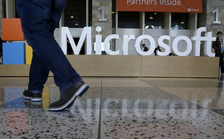 In this photo, a man walks past a Microsoft sign in San Francisco.