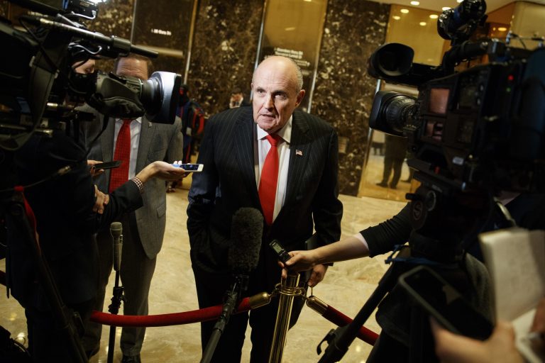 Former New York City Mayor Rudy Giuliani talks with reporters in the lobby of Trump Tower in New York.