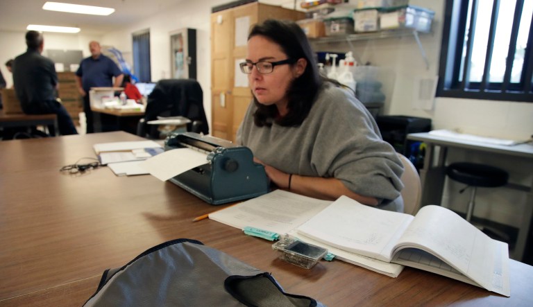 A prisoner is seen with books and a typewriter.