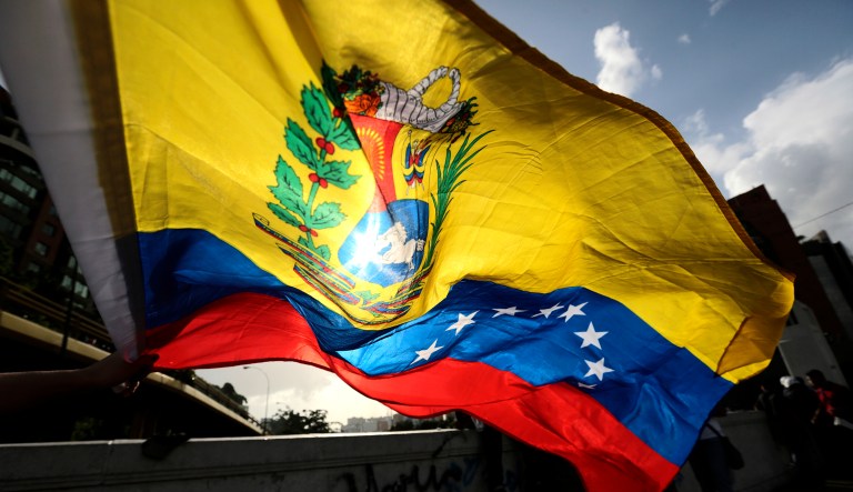 A person waves a Venezuelan flag in Caracas, Venezuela.