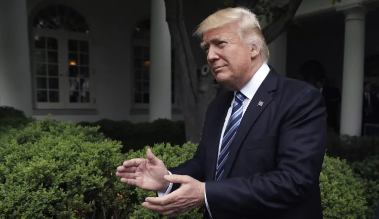 President Trump claps as he arrives in the Rose Garden of the White House in D.C.