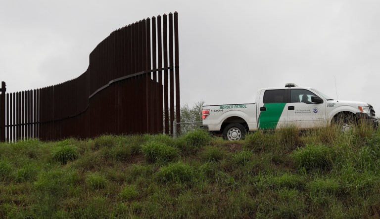 A U.S. Customs and Border Patrol agent passes along a section of border wall in Hidalgo, Texas. 