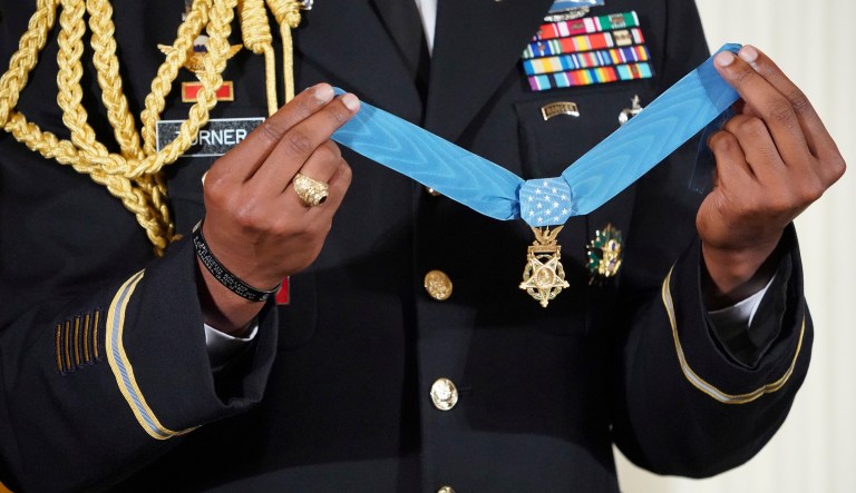 A military aide holds up the nation's highest military honor, the Medal of Honor, before President Trump bestows it. 