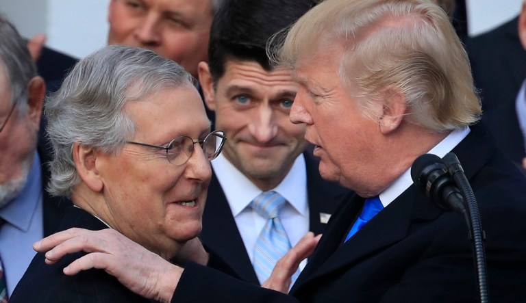 President Donald Trump congratulates Senate Majority Leader Mitch McConnell, R-Ky., while House Speaker Paul Ryan, R-Wis., watches to acknowledge the final passage of tax overhaul legislation by Congress at the White House in Washington, Wednesday, Dec. 20, 2017.
