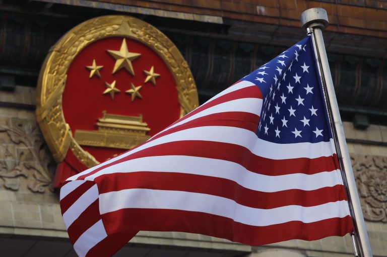 An American flag is flown next to the Chinese national emblem outside the Great Hall of the People in Beijing.