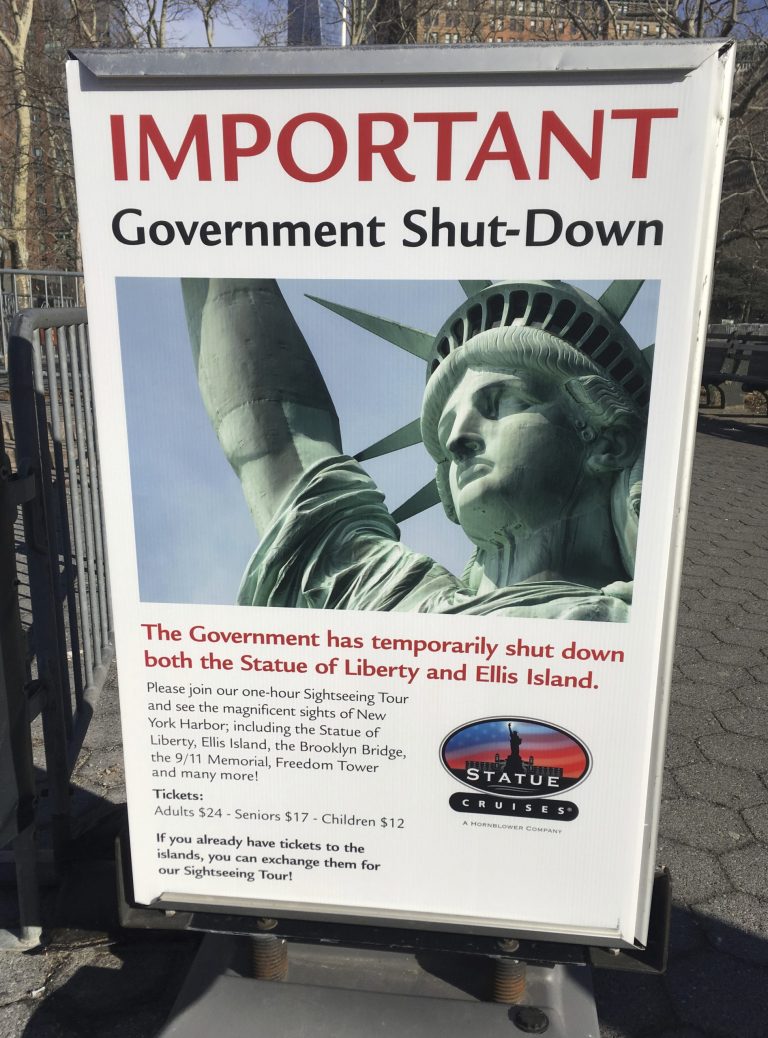 The sign at the Ellis Island ferry cue informs visitors that there was no access to the island or to the Statue of Liberty, due to the government shutdown, Saturday, Jan. 20, 2018 in New York. Another shutdown is looming.