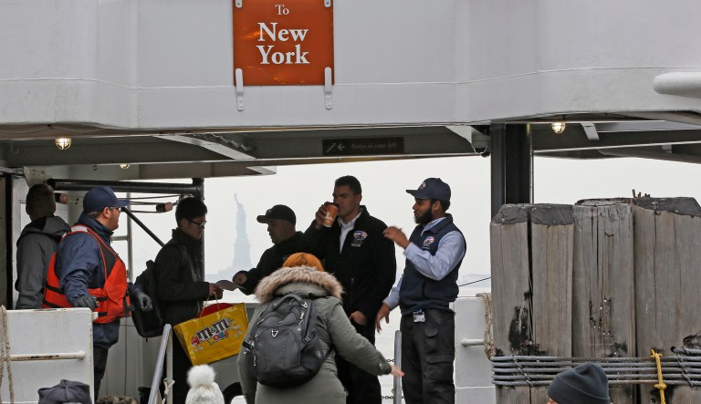 An employee take a passenger's ticket after he boarded the Miss Elllis Island, Monday, Jan. 22, 2018, in New York, before the tour boat left the dock for Ellis Island and the Statue of Liberty after New York State agreed to pay federal employees for their work during the government shutdown.