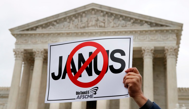 Stephen Roberts, with the American Federation of State, County and Municipal Employees, holds up a sign against Mark Janus during a rally outside of the Supreme Court on Feb. 26, 2018.