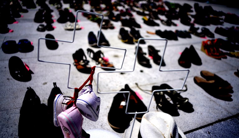 Two crosses and hundreds of shoes in memory of those killed by Hurricane Maria are displayed in front of the Puerto Rico Capitol, in San Juan, Friday, June 1, 2018.  Puerto Rico's Institute of Statistics announced that it has sued the U.S. territory's health department and demographic registry seeking to obtain data on the number of deaths following Hurricane Maria as a growing number of critics accuse the government of lacking transparency. 