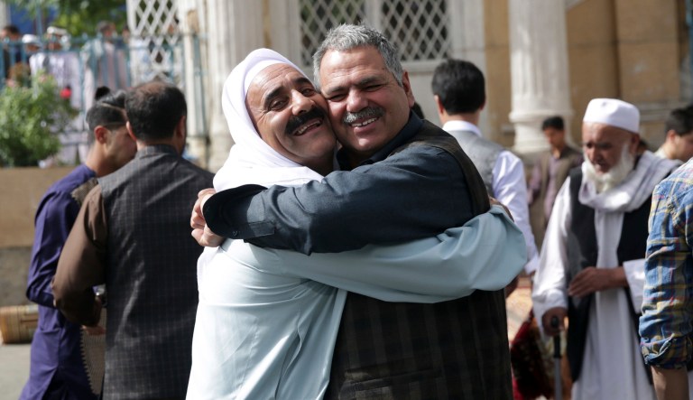 Men hug each other after Eid al-Fitr prayers outside of Shah-e-Dushamshera mosque in Kabul, Afghanistan, Friday, June 15, 2018. Taliban, an insurgent group who fight against NATO and Afghanistan's government, announced that they will start a 3-day ceasefire, starting in the first day of Eid al-Fitr. 