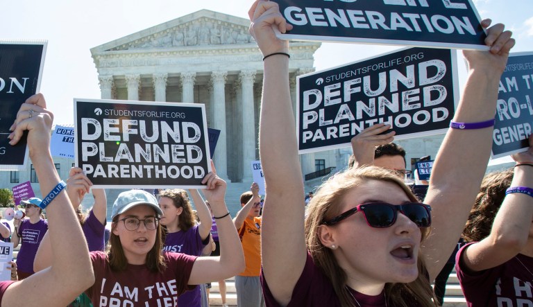 Pro-life and anti-abortion advocates demonstrate in front of the Supreme Court early Monday.