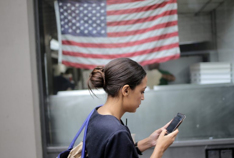 Alexandria Ocasio-Cortez checks her phone while walking to her next appointment in New York, Wednesday, June 27, 2018. The 28-year-old political newcomer who upset U.S. Rep. Joe Crowley in New York's Democrat primary says she brings an "urgency" to the fight for working families. Now she's headed to Kansas with Sen. Bernie Sanders to campaign for progressives.