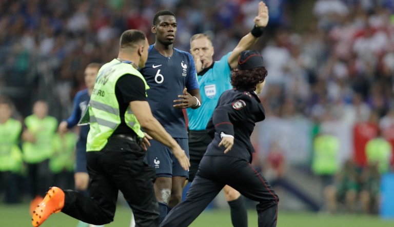 France's Paul Pogba watches a security staffer chasing a pitch invader during the final match between France and Croatia at the 2018 soccer World Cup in the Luzhniki Stadium in Moscow, Russia, Sunday, July 15, 2018. 