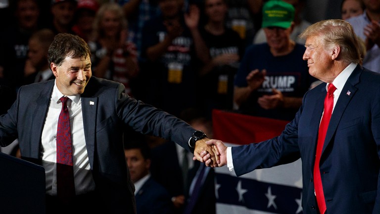 12th Congressional District Republican candidate Troy Balderson reaches for President Trump as he speaks at a rally at Olentangy Orange High School in Lewis Center, Ohio. 