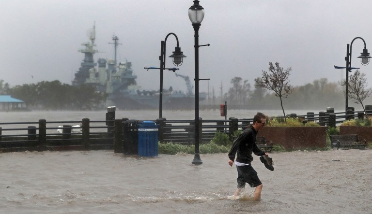A man crosses a flooded street in downtown Wilmington, N.C., after Hurricane Florence made landfall Friday.