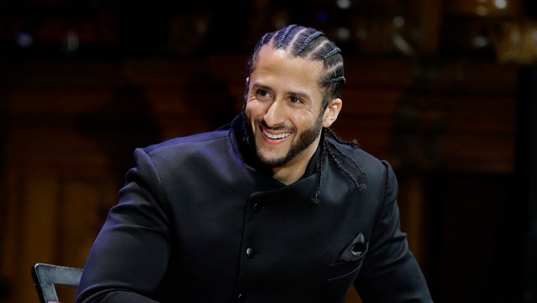 Former NFL football quarterback Colin Kaepernick is seated on stage during W.E.B. Du Bois Medal ceremonies.