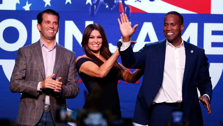 Republican U.S. Senate candidate John James, right, waves with Donald Trump Jr., and Kimberly Guilfoyle during a rally in Pontiac, Mich.
