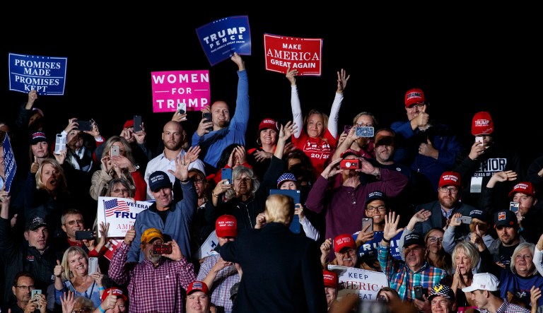 People in the audience cheer as President Trump waves to them after speaking at campaign rally at Minuteman Aviation Hangar, Thursday, Oct. 18, 2018, in Missoula, Mont.