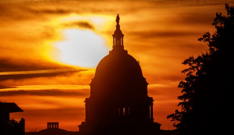 The rising sun silhouettes the U.S. Capitol dome at daybreak, Friday, Oct. 26, 2018, in Washington.