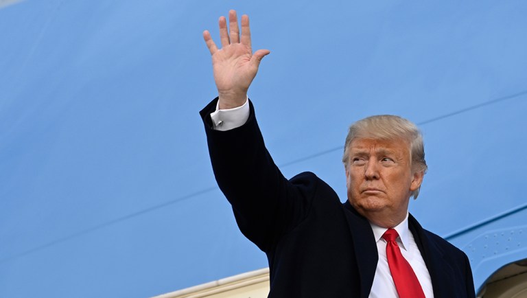 President Trump waves from the top of the steps of Air Force One.