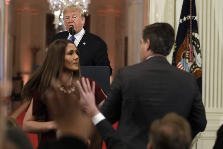 As President Donald Trump watches, a White House aide takes the microphone from CNN's Jim Acosta, during a news conference in the East Room of the White House, Wednesday, Nov. 7, 2018, in Washington.