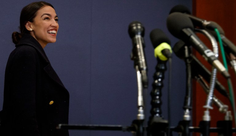 Rep.-elect Alexandria Ocasio-Cortez, D-N.Y., walks past media microphones after member-elect briefings on Capitol Hill in Washington, Thursday, Nov. 15, 2018.