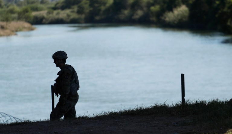 A member of the U.S. military helps install concertina wire along the banks of the Rio Grande near the Juarez-Lincoln Bridge at the U.S.-Mexico border, Friday, Nov. 16, 2018, in Laredo, Texas.
