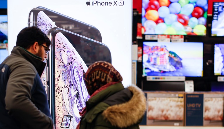 Shoppers browse Apple iPhones during a Black Friday sale at a Target store, Friday, Nov. 23, 2018, in Newport, Ky.