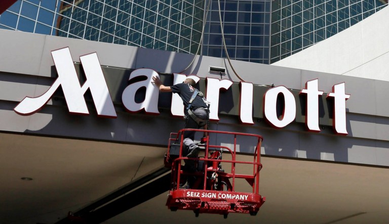 A worker installs a new Marriott sign.