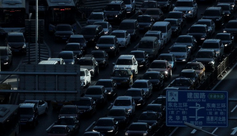 A beam of sunlight is cast on vehicles on a city ring-road clogged with heavy traffic during the morning rush hour in Beijing, China, Tuesday, Dec. 11, 2018.