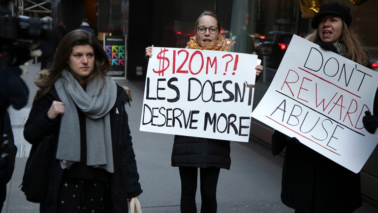 Protesters stand outside the site of the CBS shareholder's meeting in New York.