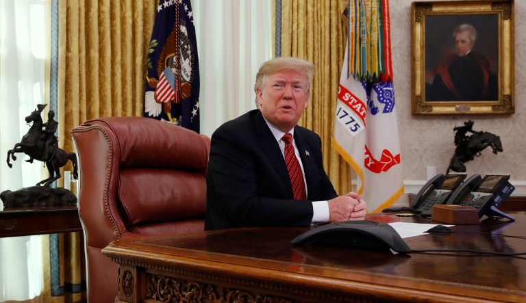 President Trump answers questions from the media after speaking with members of the military by video conference on Christmas Day, Tuesday, Dec. 25, 2018, in the Oval Office of the White House.