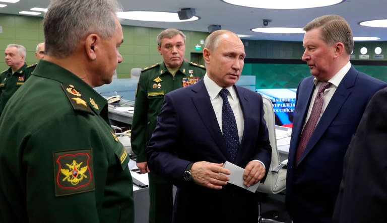 Russian Defense Minister Sergei Shoigu, left, Russian President Vladimir Putin, center, Chief of General Staff of Russia Valery Gerasimov, background center, and special representative on questions of ecology and transport, Sergei Ivanov, right, talk to each other as they come to oversee the test launch of the Avangard hypersonic glide vehicle from the Defense Ministry's control room in Moscow, Russia, Wednesday, Dec. 26, 2018. In the test, the Avangard was launched from the Dombarovskiy missile base in the southern Ural Mountains. The Kremlin says it successfully hit a designated practice target on the Kura shooting range on Kamchatka, 6,000 kilometers (3,700 miles) away.