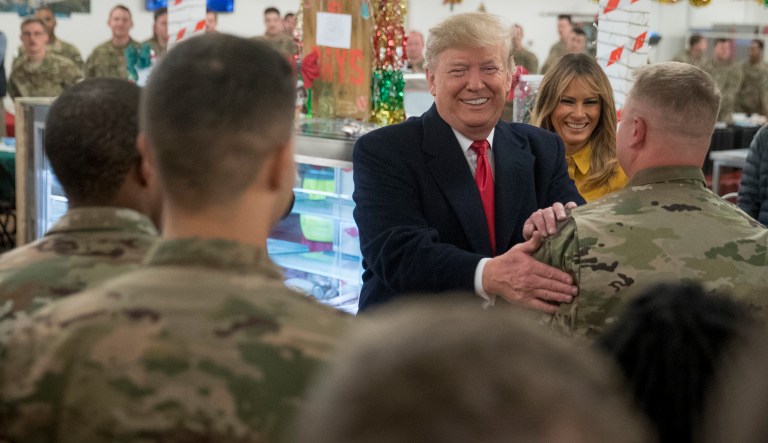 President Trump and first lady Melania Trump visit with members of the military at a dining hall at Al Asad Air Base, Iraq, Wednesday, Dec. 26, 2018. In a surprise trip to Iraq, Trump on Wednesday defended his decision to withdraw U.S. forces from Syria where they have been helping battle Islamic State militants.