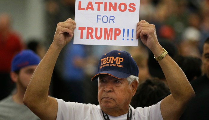 FILE - In this May 25, 2016, file photo, a man holds up a sign for then-Republican presidential candidate Donald Trump before the start of a rally at the Anaheim Convention Center, Wednesday, May 25, 2016, in Anaheim, Calif. Republicans are holding onto a steady share of the Latino vote in the Trump era. With a president who targets immigrants from Latin America, some analysts predicted a Latino backlash against the GOP. But it hasnât happened. Data from APâs VoteCast survey suggests Republicans are holding on to support from Latino evangelicals and veterans.
