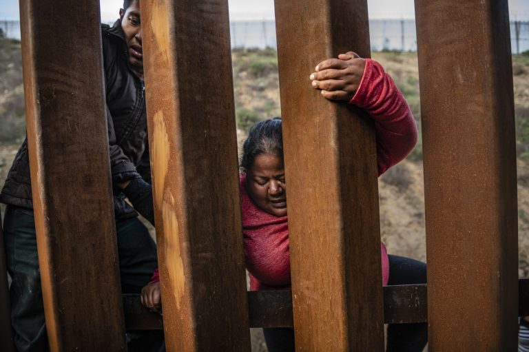 A migrant climbs the border fence before jumping into the U.S. to San Diego, Calif., from Tijuana, Mexico, Thursday, Dec. 27, 2018.