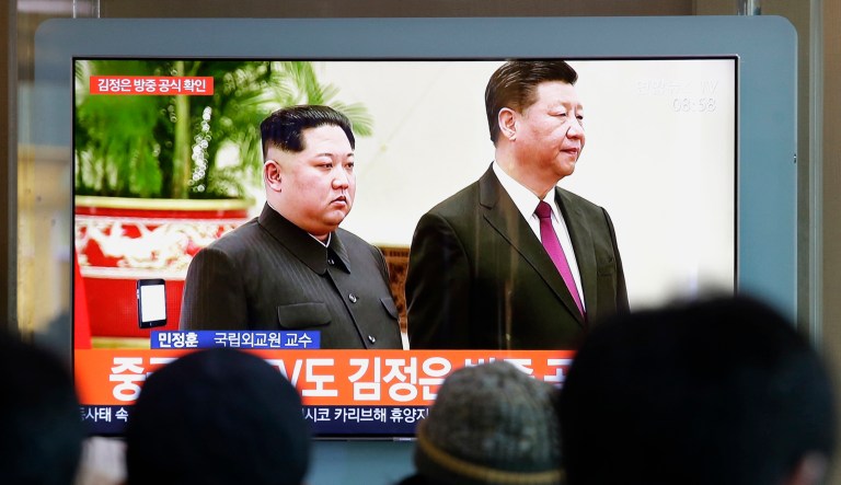 People watch a TV screen showing file footage of North Korean leader Kim Jong Un and Chinese President Xi Jinping, right, during a news program at the Seoul Railway Station in Seoul, South Korea.